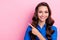 Photo of girlish fancy positive nice woman with curly hairdo dressed blue blouse directing empty space isolated on pink