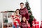 Photo of glad peaceful family cuddle infant small baby new year harmony wear sweater in decorated x-mas home indoors