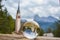 Photo through a glass ball. Church of San Giacomo. Ortisei, Gardena Valley, South Tyrol, Dolomites, Italy