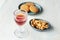 A photo of a glass of sweet wine with cookies and nuts