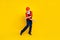 Photo of good mood cool senior guy dressed uniform overall red hardhat having fun dancing isolated yellow color