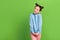 Photo of good mood friendly schoolgirl with buns dressed blue pullover look at offer empty space isolated on green color