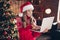 Photo of good mood sweet small girl wear red print sweater typing modern device new year xmas greetings indoors house