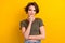 Photo of gorgeous pleasant satisfied girl with bob hairstyle dressed khaki t-shirt hold hand on chin isolated on yellow