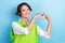 Photo of gorgeous pretty positive lady wear trendy clothes arms demonstrate heart figure empty space isolated on cyan