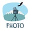 Photo graphic icon. A camera on a tripod among the mountain landscape
