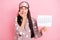 Photo of guilty scared young woman sleepwear biting fingers holding paper calendar isolated pink color background