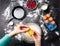 Photo of hands of man breaking eggs in bowl. Table with berries, milk, flour.