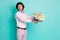 Photo of handsome beaming gentle man wear pink outfit presenting bouquet flowers birthday party isolated teal color