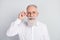 Photo of handsome cheerful grey hair old man touch spectacles wear white shirt  on grey color background