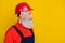 Photo of handsome confident senior guy dressed uniform overall red hardhat looking empty space isolated yellow color