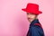 Photo of handsome cool young man wear blue shirt red headwear looking you suspicious empty space  pink color