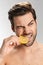 Photo of handsome half-naked man looking aside and eating lemon