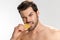 Photo of handsome half-naked man looking at camera and eating lemon