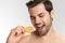 Photo of handsome half-naked man smiling and eating lemon