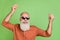 Photo of handsome senior man good mood dancer clubber wear glasses careless isolated over green color background