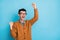 Photo of happy astonished young man raise fists look empty space winner isolated on blue color background