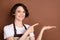 Photo of happy beautiful woman barista coffee shop assistant demonstrate product  on brown color background