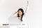 Photo of happy chinese businesswoman with long dark hair screaming with raised arms while working with documents and