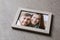 Photo of happy couple in frame with cracked glass on table. Concept of divorce