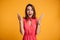 Photo of happy excited amazed young woman in red dress standing