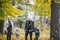 Photo of happy family in autumn park, parents with cheerful babies playing in fall forest