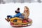 Photo of happy girl and boy riding tubing