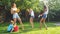 Photo of happy laughing family splashing water with water guns and garden hose at backyard. People playing and having