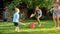 Photo of happy laughing family splashing water with water guns and garden hose at backyard. People playing and having