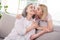 Photo of happy mother and daughter good mood sit sofa kiss cheek trust care indoors inside house home flat