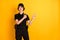 Photo of happy smiling beautiful policewoman in black uniform point finger copyspace advertise isolated on yellow color