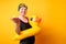 Photo of happy woman in bathing suit with lifebuoy on empty orange background