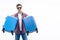 Photo of happy young man ready for the trip with his suitcase packed over white background.