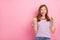 Photo of hooray small blond girl index empty space wear red t-shirt isolated on pink color background