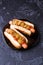 Photo of hotdogs on black plate