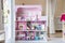 The photo of huge pink dollhouse model furnished with miniature furniture in a kidâ€™s room