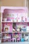 The photo of huge pink dollhouse model furnished with miniature furniture in a kidâ€™s room