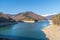 Photo of the Iezer-Papusa mountains with their snowy peaks and the orange nature took at Rausor Lake and Dam, Arges, Romania