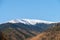 Photo of the Iezer-Papusa mountains with their snowy peaks and the orange nature took at Rausor Lake and Dam, Arges, Romania