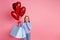 Photo of impressed appreciative woman hold heart shape bubbles get presents on birthday hand on cheek isolated on pink
