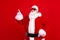 Photo of impressed astonished grandfather wear santa costume staring indicating at logo empty space isolated on red