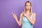 Photo of impressed blond young lady point empty space wear blue top isolated on violet color background