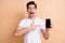 Photo of impressed guy open mouth indicate finger phone display unbelievable proposition isolated on beige color