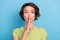 Photo of impressed serious young woman dressed green t-shirt finger lips asking keep silence isolated blue color