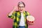 Photo of impressed woman with short hairstyle wear checkered shirt touch glasses hold popcorn at cinema isolated on pink
