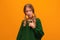 Photo of indignant blonde teen pointing finger at herself, has dissatisfied expression. Studio shot, yellow background