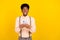 Photo of inspired thoughtful guy hold phone look empty space wear suspenders shirt isolated yellow color background