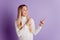 Photo of interested small lady direct finger empty space wear white jumper posing on purple background