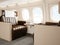 Photo interior of luxury private jet. Empty leather chair, modern generic design laptop table. Blank white screen ready