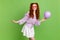 Photo of joyful orange hairstyle young lady hold balloon look empty space wear violet blouse skirt spectacles isolated